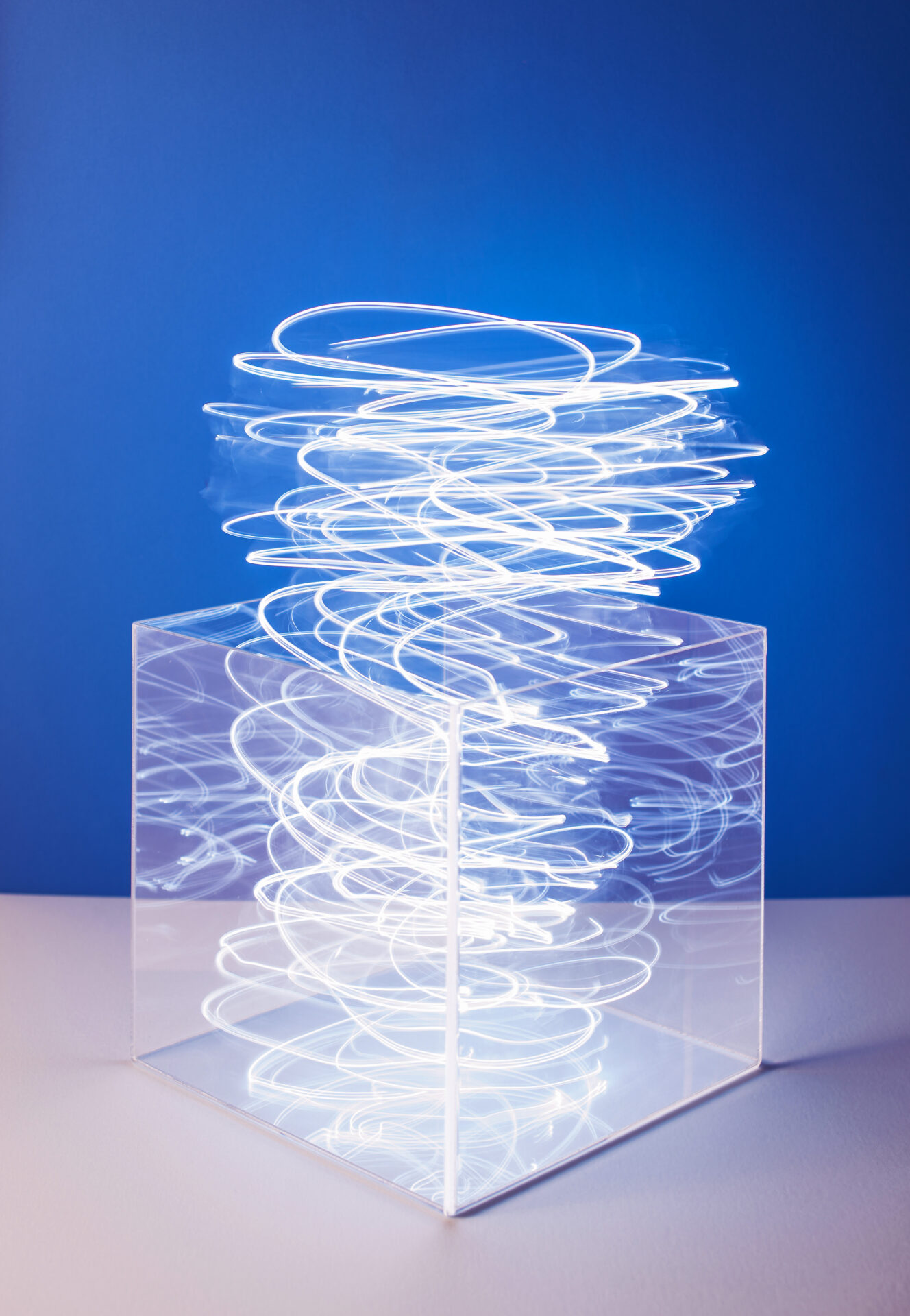 A transparent box with a strong of light inside and above it