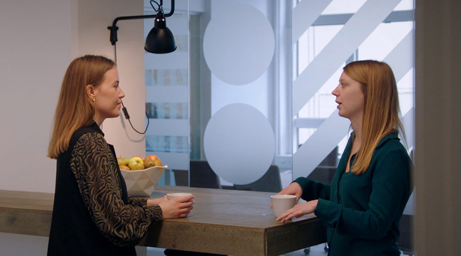Devoteam Data Team: two women talking in a modern office.