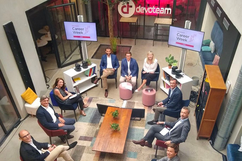 Ein Team von Devoteam-Kolleg*innen während der Career Week bei Devoteam, das zusammenarbeitet und über Karrieremöglichkeiten im Bereich Tech Leadership Jobs spricht.