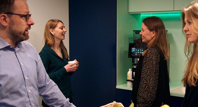 Devoteam Data team: men and women talking by a coffee machine