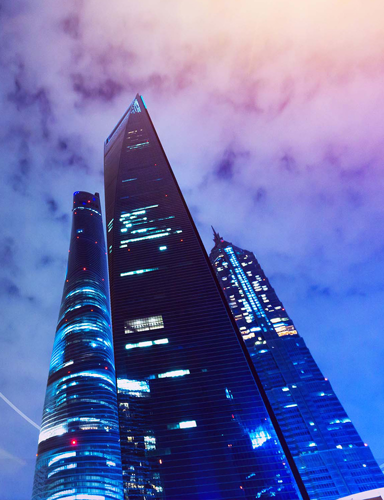Skyscrapers in a blue light with clouds in a backgroudn